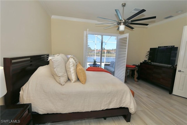 bedroom with a water view, light wood finished floors, visible vents, and ornamental molding