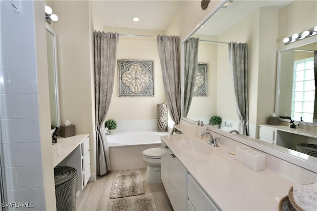 full bath with wood finished floors, vanity, and a bath