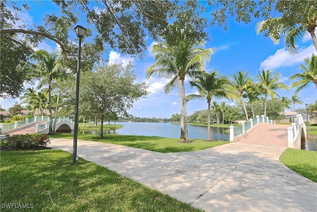 view of property's community with a water view and a yard