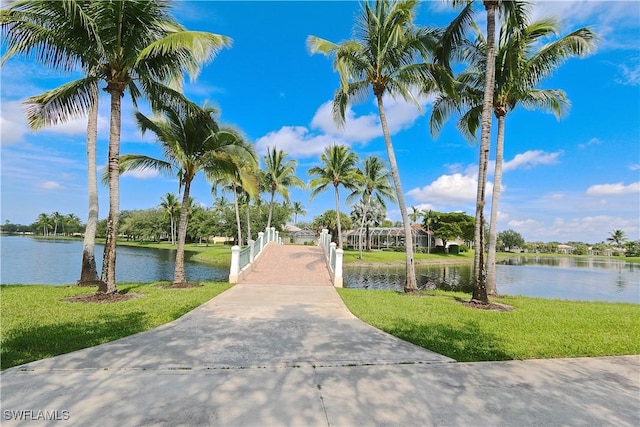 surrounding community featuring a lawn and a water view