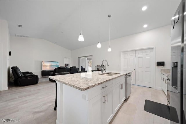 kitchen featuring lofted ceiling, a sink, white cabinetry, light stone countertops, and dishwasher