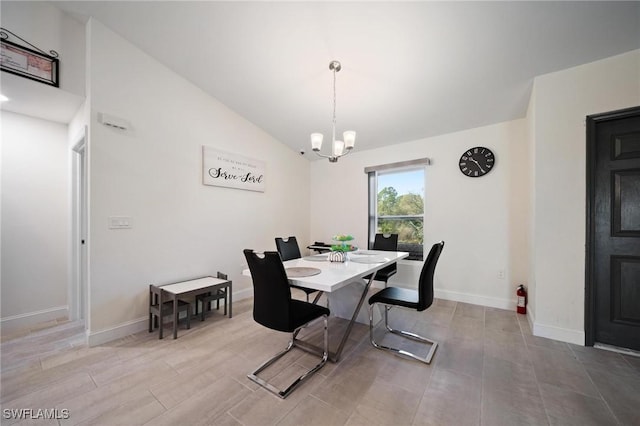 dining space featuring a chandelier, lofted ceiling, and baseboards