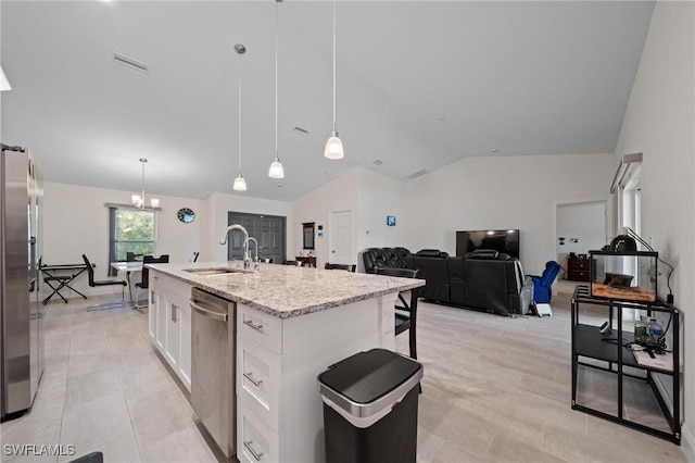 kitchen with stainless steel appliances, white cabinetry, vaulted ceiling, a sink, and light stone countertops