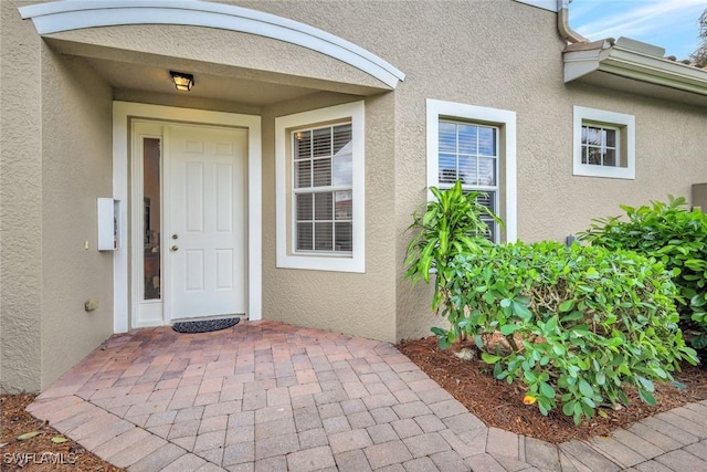 view of exterior entry featuring stucco siding