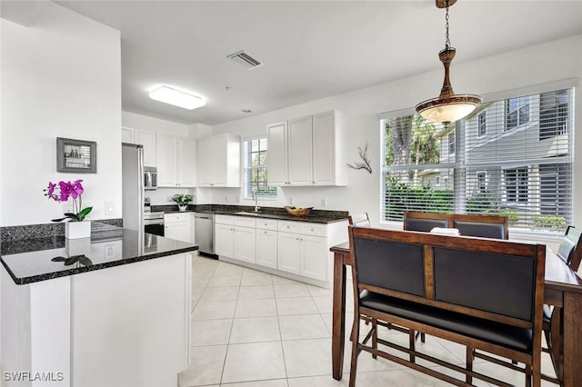 18911 Bay Woods Lake Dr Unit 101, Fort Myers, FL 33908 - kitchen with light tile patterned floors, a sink, a peninsula, appliances with stainless steel finishes, and white cabinetry