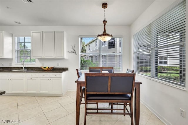 dining space featuring light tile patterned floors, plenty of natural light, and baseboards