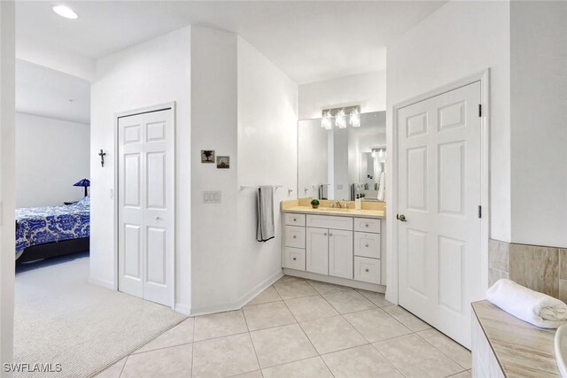 full bathroom with baseboards, connected bathroom, vanity, and tile patterned floors