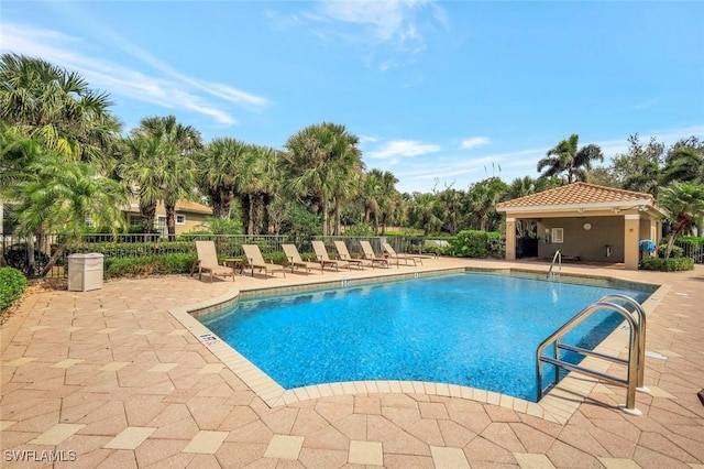 pool with a patio and fence