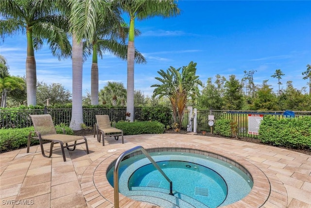 view of pool featuring a patio, fence, and a hot tub