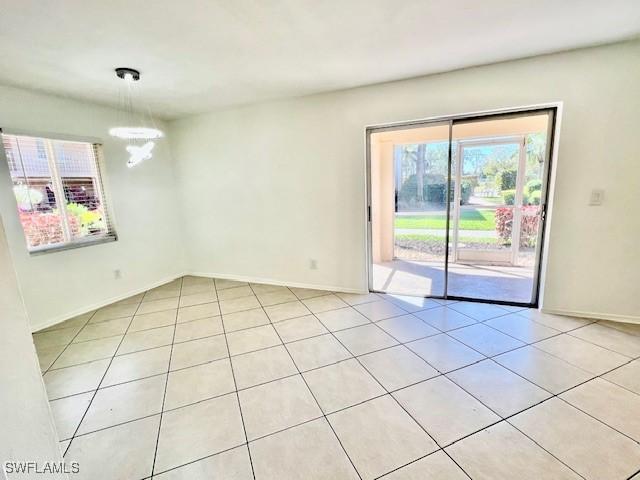 spare room with baseboards and light tile patterned floors