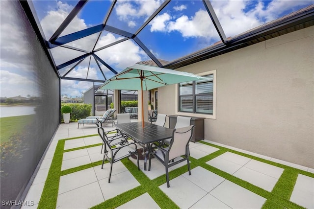 view of patio featuring outdoor dining space, glass enclosure, and a water view