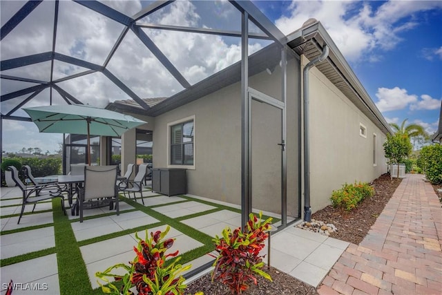 view of patio / terrace featuring outdoor dining space and glass enclosure