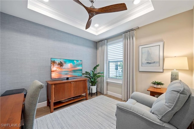 office area with baseboards, ornamental molding, a raised ceiling, and wood finished floors