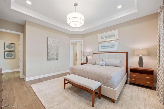 bedroom with light wood-type flooring, a raised ceiling, and crown molding