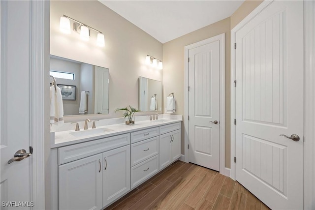 bathroom featuring double vanity, a sink, and wood finished floors