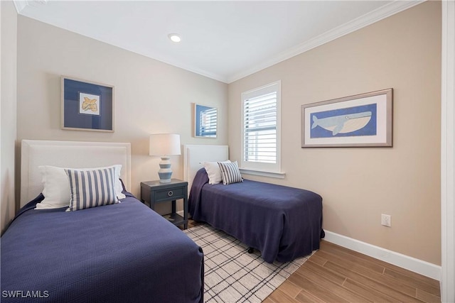 bedroom with crown molding, light wood-type flooring, and baseboards