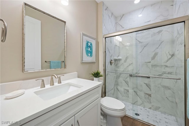 bathroom featuring vanity, a marble finish shower, and toilet