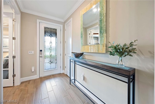 entryway featuring baseboards, light wood-type flooring, and crown molding