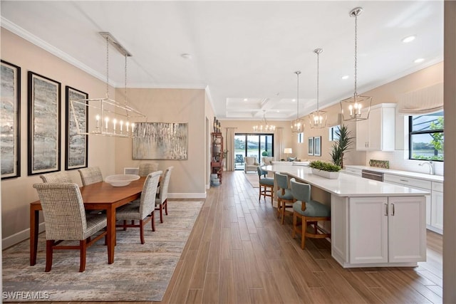 dining area featuring ornamental molding, baseboards, a notable chandelier, and light wood finished floors