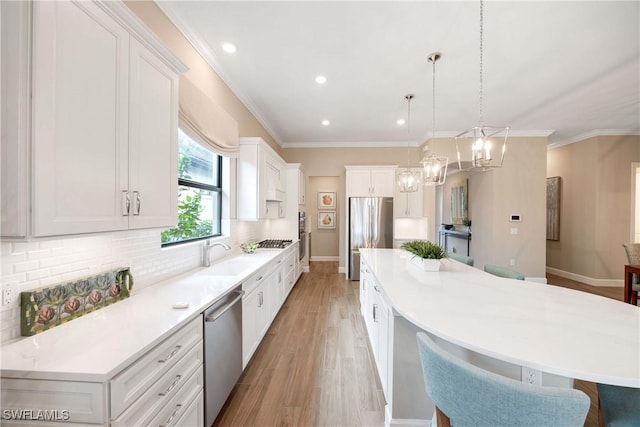 kitchen with stainless steel appliances, a sink, a large island, light wood-type flooring, and tasteful backsplash