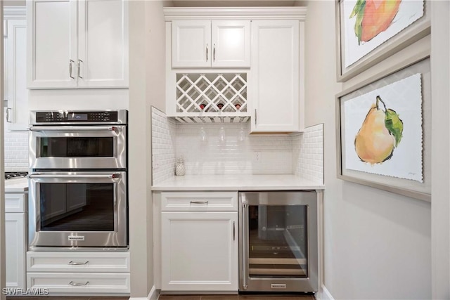 bar with double oven, wine cooler, backsplash, and a dry bar