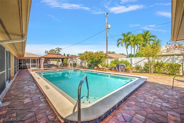 view of pool with a fenced in pool, a gazebo, a sunroom, a patio area, and fence