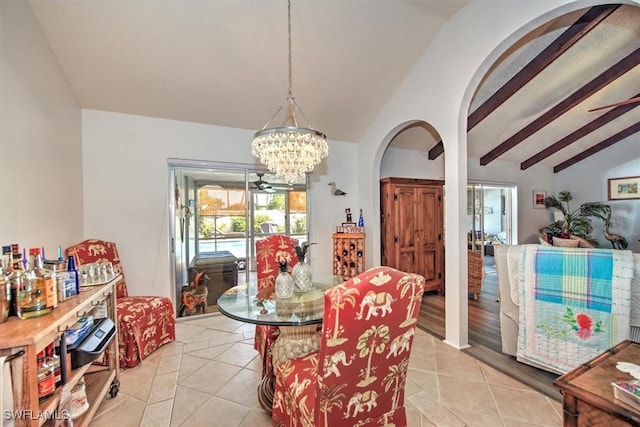 dining space with a chandelier, arched walkways, lofted ceiling with beams, and light tile patterned floors