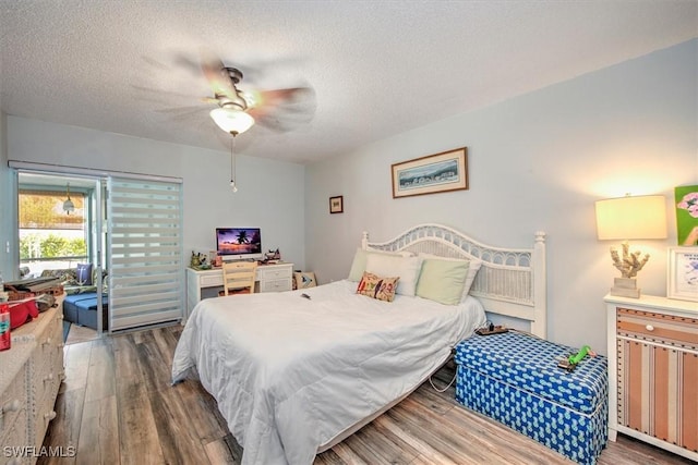 bedroom featuring a ceiling fan, a textured ceiling, and wood finished floors