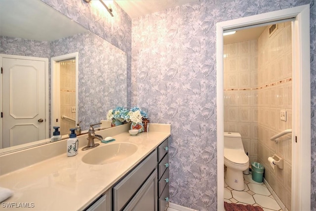 bathroom featuring vanity, toilet, and wallpapered walls