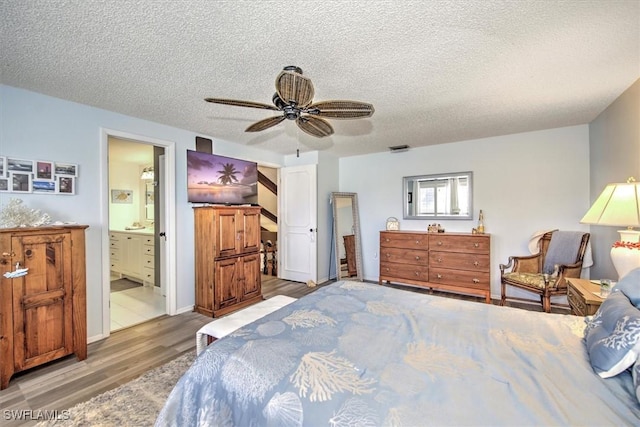 bedroom featuring connected bathroom, a textured ceiling, a ceiling fan, and wood finished floors