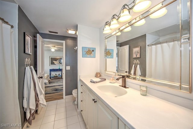 bathroom featuring toilet, vanity, baseboards, visible vents, and tile patterned floors