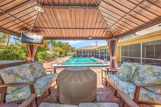 view of patio / terrace featuring a sunroom, outdoor lounge area, an outdoor pool, and a gazebo