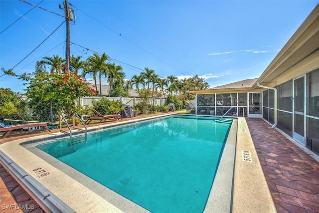 community pool with a patio, fence, and a sunroom