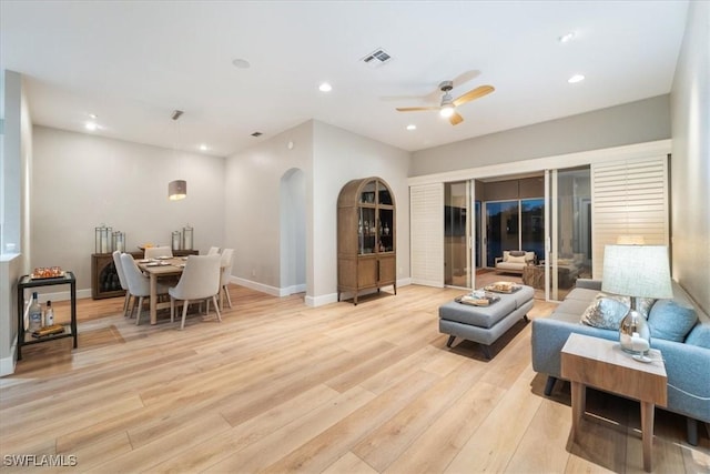 living area featuring baseboards, visible vents, ceiling fan, light wood-style floors, and recessed lighting