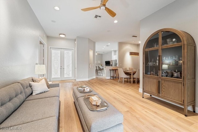 living area featuring light wood-type flooring, french doors, visible vents, and recessed lighting