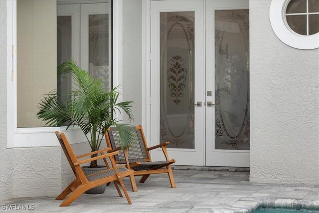 entrance to property featuring stucco siding and french doors