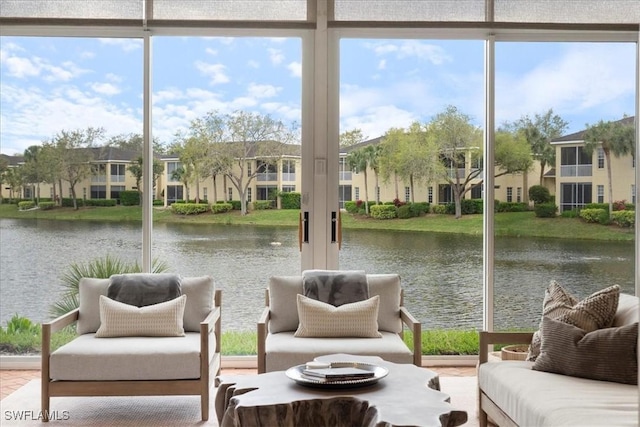 unfurnished sunroom with a residential view and a water view