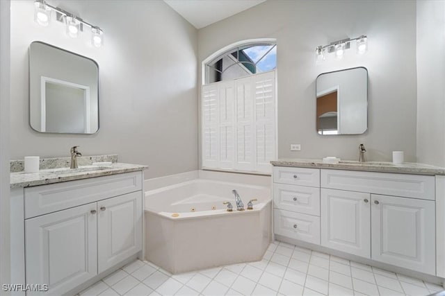 bathroom with two vanities, a sink, and a whirlpool tub