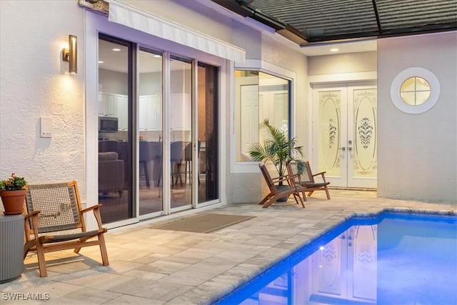 pool with french doors and a patio area