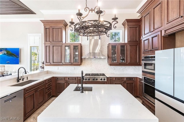 kitchen featuring wall chimney exhaust hood, appliances with stainless steel finishes, a sink, and ornamental molding