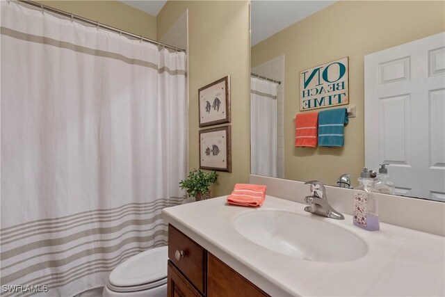 full bathroom featuring toilet, curtained shower, and vanity