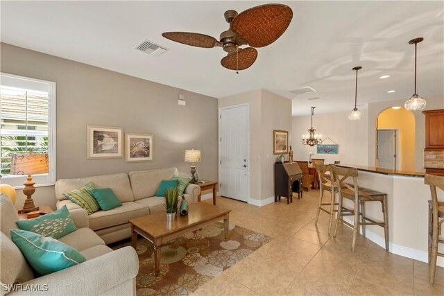 living room with arched walkways, recessed lighting, visible vents, baseboards, and ceiling fan with notable chandelier