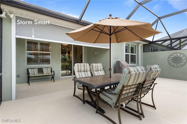 view of patio / terrace featuring glass enclosure and outdoor dining space