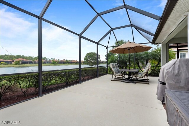 view of patio / terrace featuring a water view, glass enclosure, and outdoor dining space