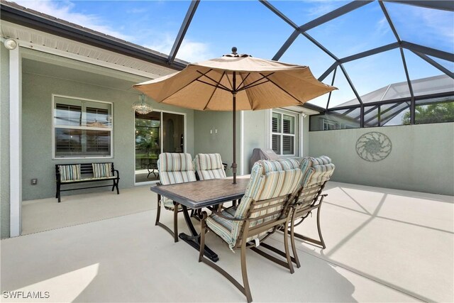 view of patio featuring outdoor dining area and glass enclosure