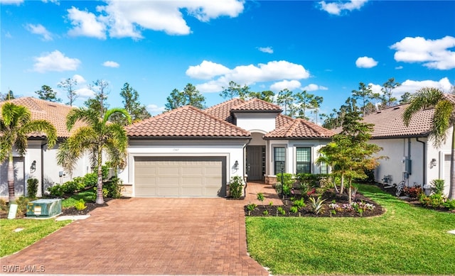 mediterranean / spanish-style house featuring an attached garage, a tile roof, decorative driveway, stucco siding, and a front lawn