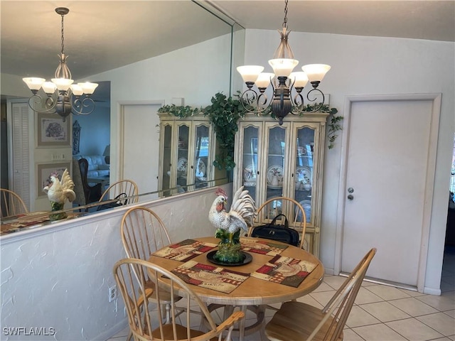 dining area with light tile patterned floors, lofted ceiling, and an inviting chandelier