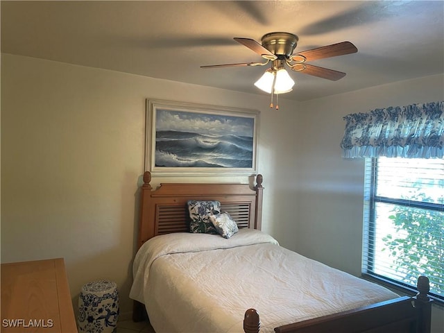 bedroom with a ceiling fan and multiple windows