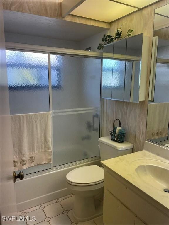 bathroom with combined bath / shower with glass door, vanity, and toilet