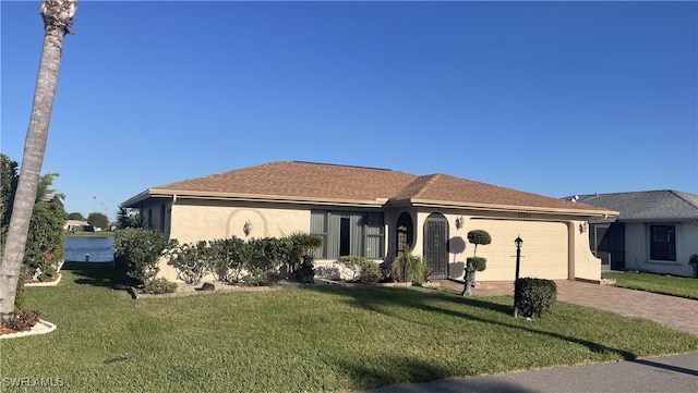 ranch-style home with a garage, a front yard, decorative driveway, and stucco siding